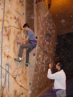 Members of the rock climbing group scling the indoor wall.