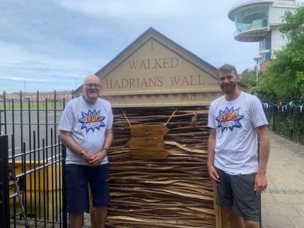 Image of Mike Ford and his son Olly wearing EyUp! T-shirts at the finishing line for Hadrian's wall.