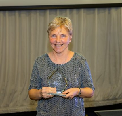A photo of a woman holding an award