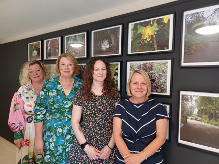 Four women stood in front of photos.