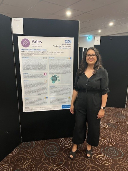 A woman standing in front of a conference poster