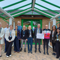 Colleagues standing outside the Cullingworth Street Hub with a sign to open the new sensory room