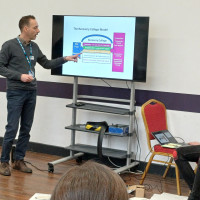 Recovery College Hong Kong delegation visit - person pointing to presentation on screen