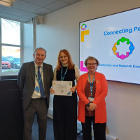 Chief Executive Mark Brooks and Chair Marie Burnham standing with connector and their certificate