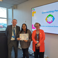 Chief Executive Mark Brooks and Chair Marie Burnham standing with connector and their certificate