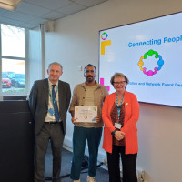 Chief Executive Mark Brooks and Chair Marie Burnham standing with connector and their certificate