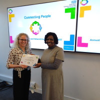 Presenter and connector standing with their certificate