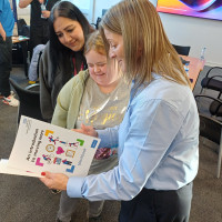 Three colleagues reading a leaflet