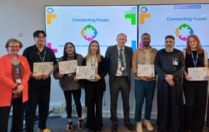 Chief Executive Mark Brooks and Chair Marie Burnham standing with our newly qualified community connectors holding their certificates