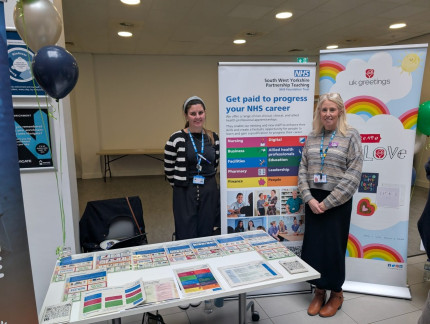 Two colleagues standing at a stall at Kirklees College careers event