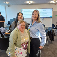 Three colleagues standing at a Trust learning event