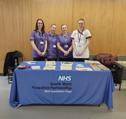 Colleagues standing behind a table offering nutrition advice to the public