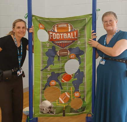 Photo of two people stood next to a football game